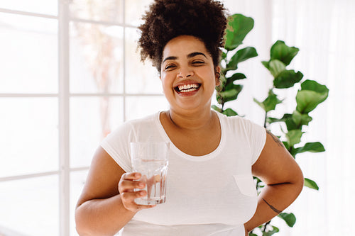 Healthy woman with glass of water at home