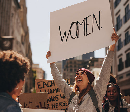 Happy woman protesting with hand written sign