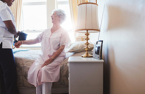 Nurse taking blood pressure of senior woman