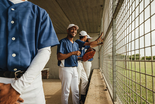 Teamwork in sports: Baseball players in the dugout eagerly watch the game