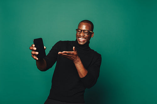 Happy man recommending trendy app on green background