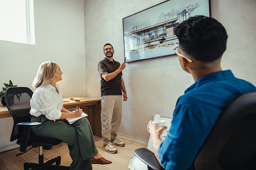 Architects discussing building design with presentation in a creative office space