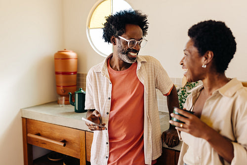 Happy Afro-Brazilian couple standing in kitchen, enjoying quality time together