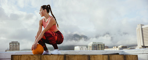 Sportswoman taking break from workout on rooftop