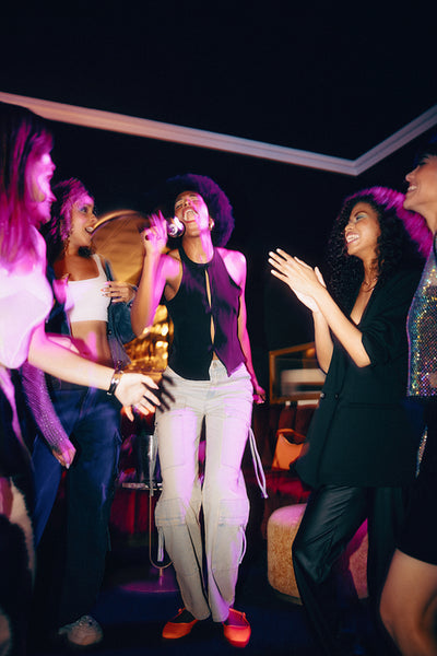 Group of friends enjoying karaoke and celebration in a vibrant indoor setting