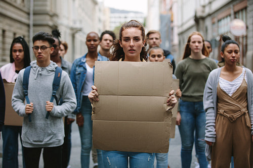 People doing demonstration on the street holding sign boards