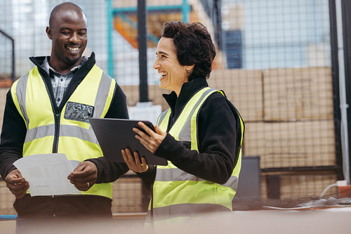 Happy warehouse workers smiling cheerfully during a meeting