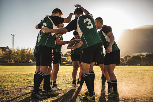 Rugby players cheering together after the game