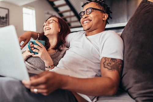 Cheerful multi-ethnic couple relaxing at home