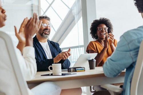 Diverse business team celebrating successful project in a boardroom