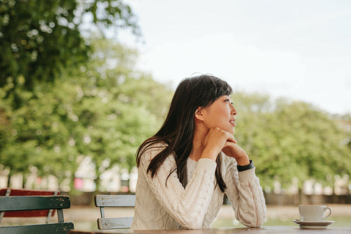 Chinese female relaxing at outdoor cafe