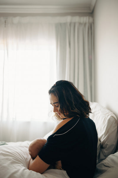 Mother nursing baby in morning light