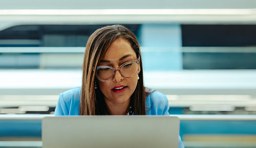 Confident businesswoman working diligently on her laptop at the office