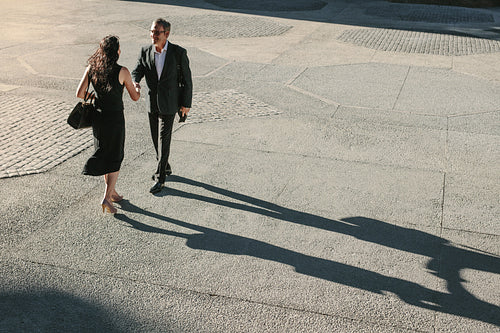 Business colleagues meeting each other on a street while commuting to office