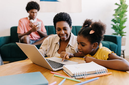 Mom and daughter engaging in educational activities with a laptop