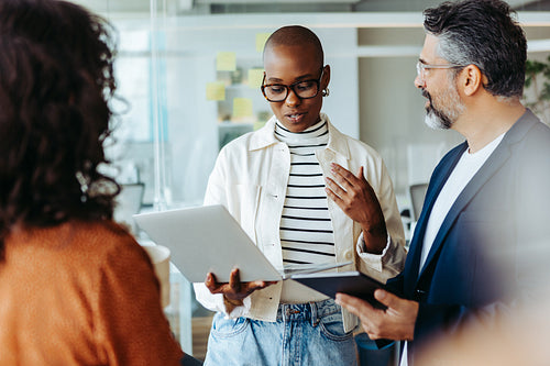 Young business woman having a cooperative discussion with her team in a standup meeting