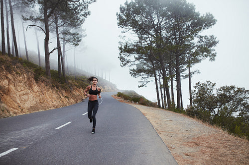 Fitness woman running on open country road