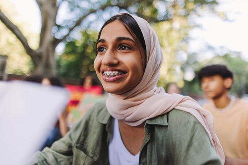 Muslim girl smiling happily at a climate protest