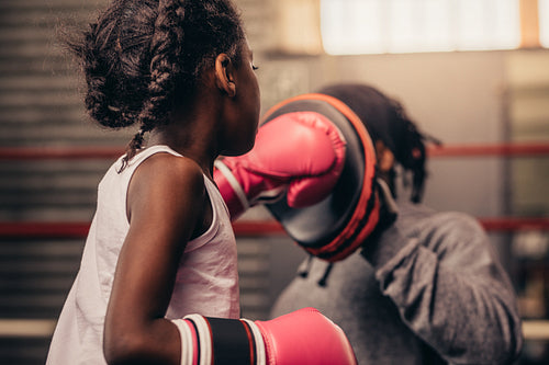 Rear view of a boxing kid practicing her punches