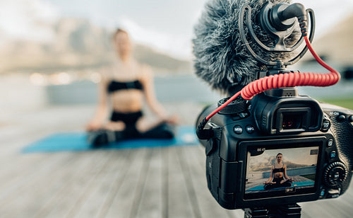 Female blogger recording yoga content on camera