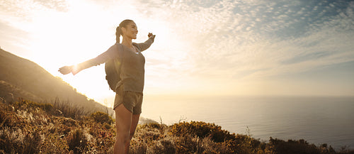 Woman embracing freedom while hiking near the ocean