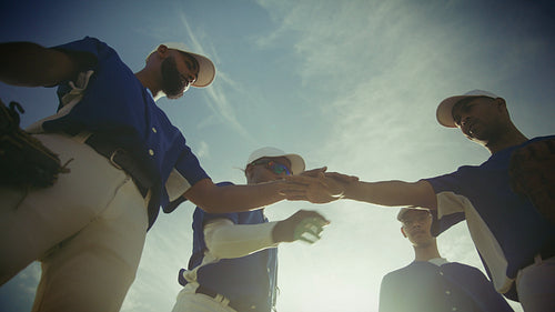Baseball team huddles and throws ball skyward