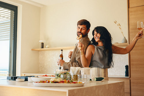 Couple enjoying fun moments in the kitchen while preparing a meal together