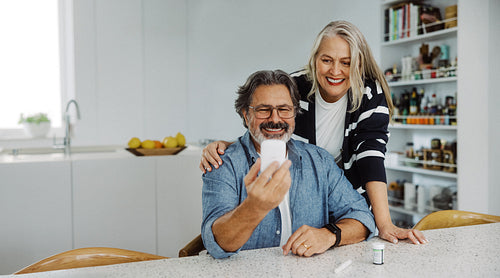 Senior couple checks blood glucose at home