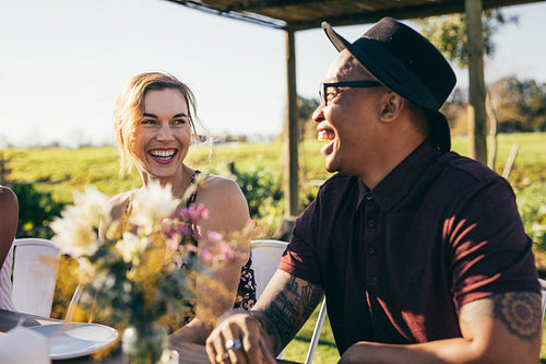 Cheerful young guy with friends at restaurant