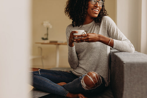 Woman enjoying a cup of coffee sitting at home