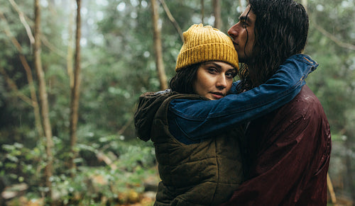 Couple in love embracing in the park under rain