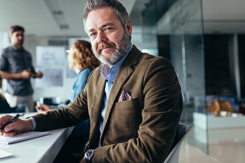 Mature businessman sitting in meeting room
