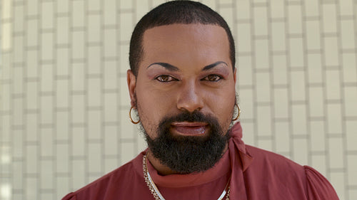 Genderqueer with makeup looking at camera