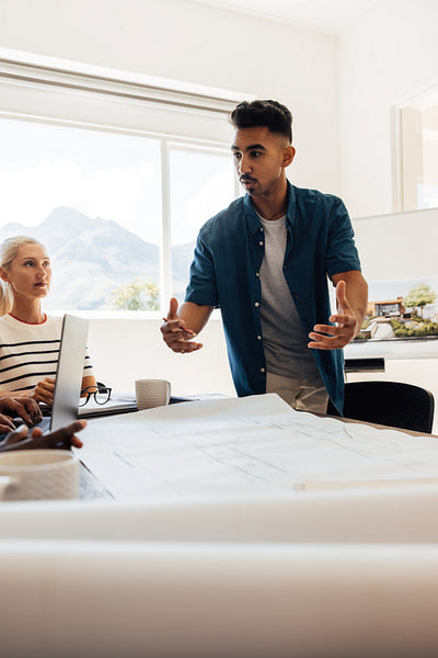 Architects discussing blueprints during a team meeting in a modern office space