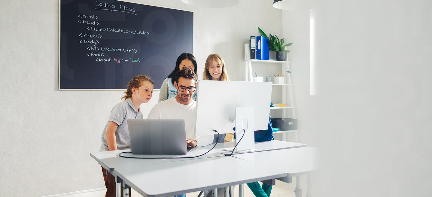Elementary school teacher leading a coding lesson in a classroom, usin ...