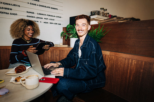 Friends working together in a casual cafe workspace