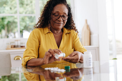 Senior woman taking prescription medication at home
