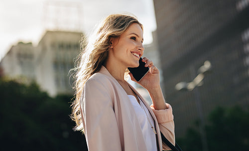 Businesswoman using cell phone walking outside