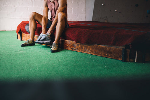 Man wall climber coating hands with gripping powder