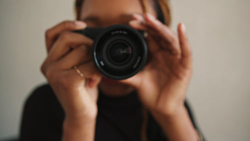 Young female photographer taking pictures in her home studio