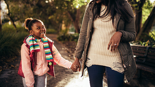 Cute little girl with mother walking outdoors