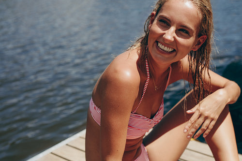 Smiling woman on a holiday relaxing near a lake.