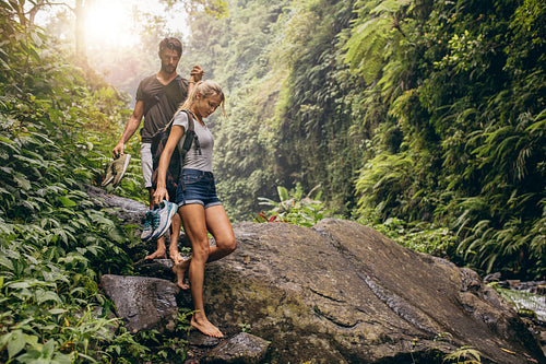Young couple walking through the mountain trail.