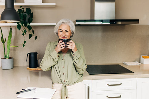Elderly woman enjoying a cup of coffee at home