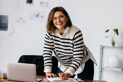 Her business woman routine includes writing in a notebook at the desk