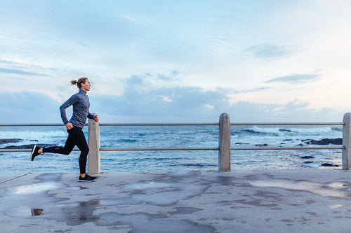 Female runner running on seaside promenade