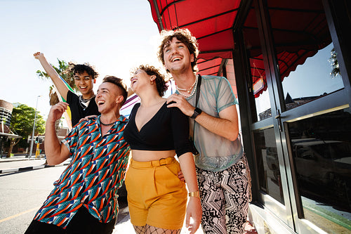 Happy LGBTQ+ people parading the rainbow pride flag