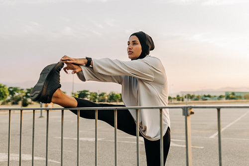 Muslim woman stretching her legs outdoors in the morning