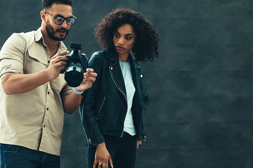 Photographer showing image in camera to a model