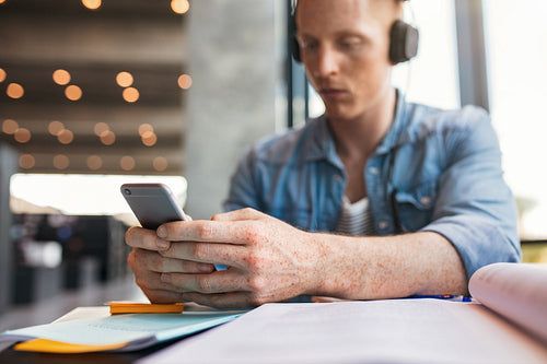 University student using mobile phone in library